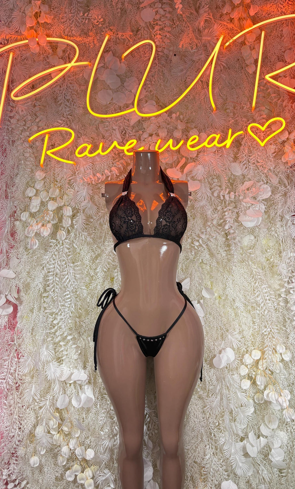 Black lace strappy bikini set on mannequin, triangle cups and adjustable tie bottoms