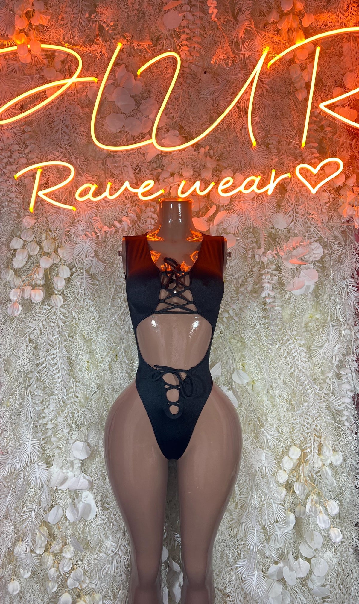 Black cutout one-piece bodysuit with lace-up front and high-cut legs