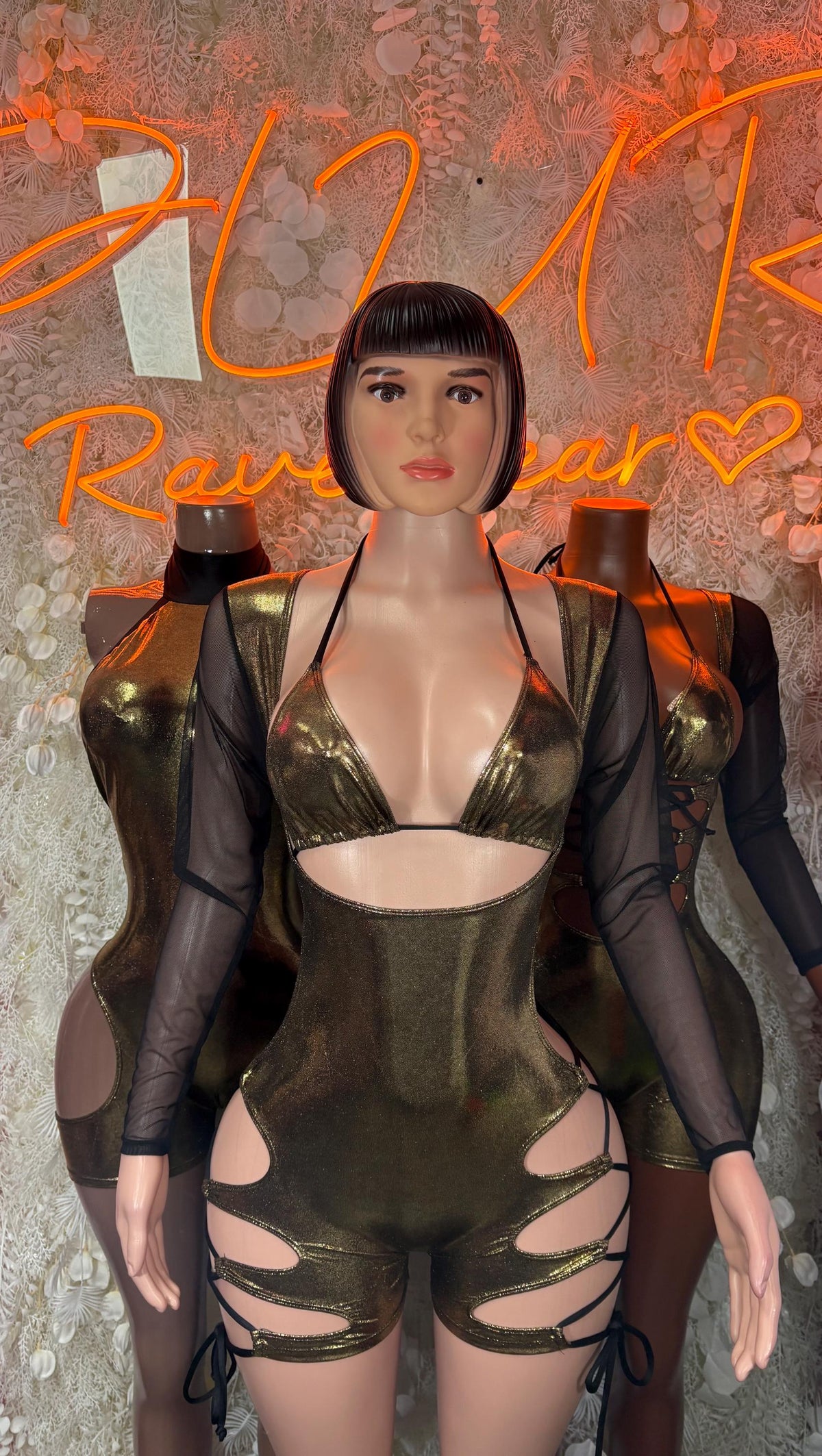Metallic gold bodysuit with black sheer sleeves and lace-up hip cutouts