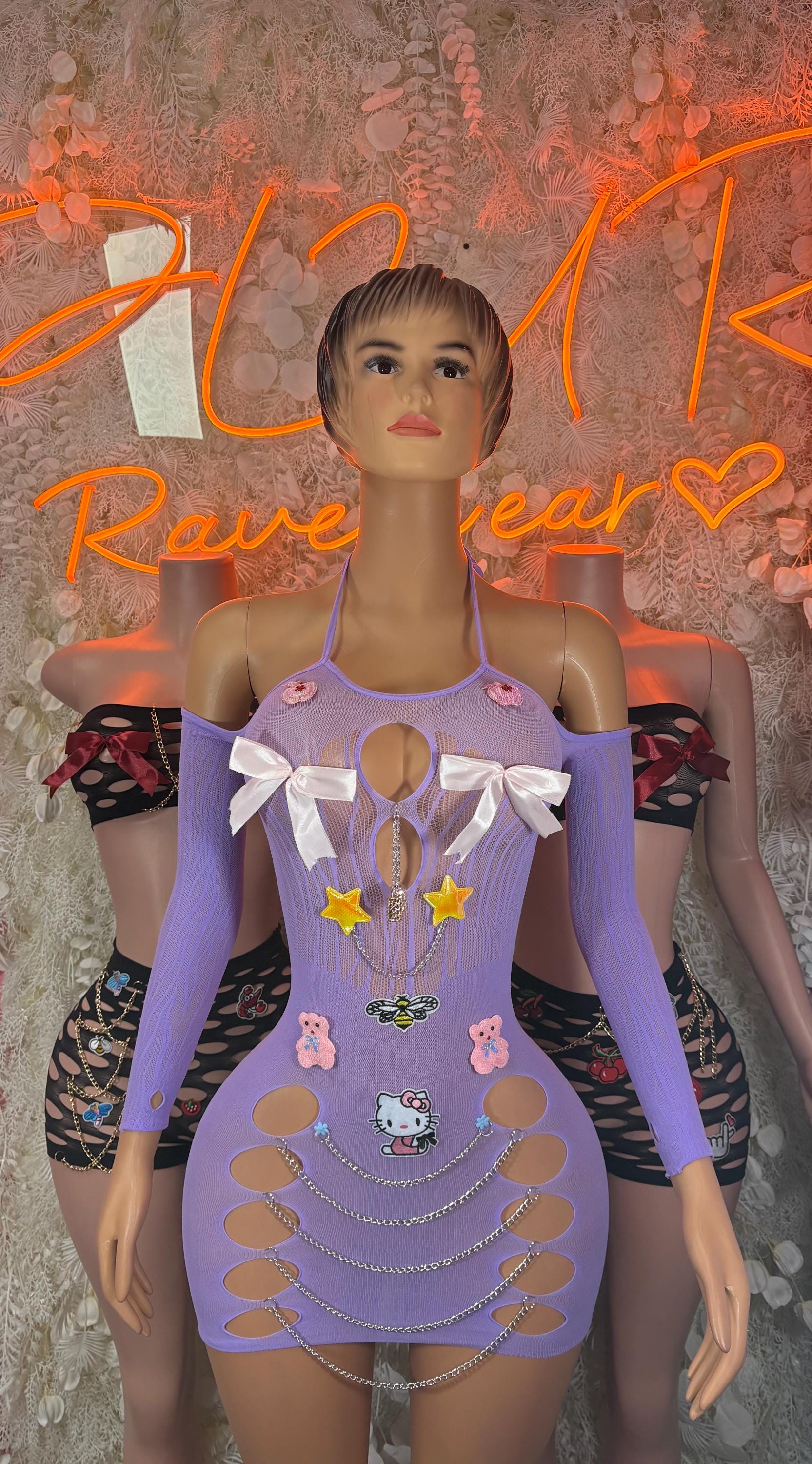 Purple mini dress with bow straps and layered accessories on mannequin