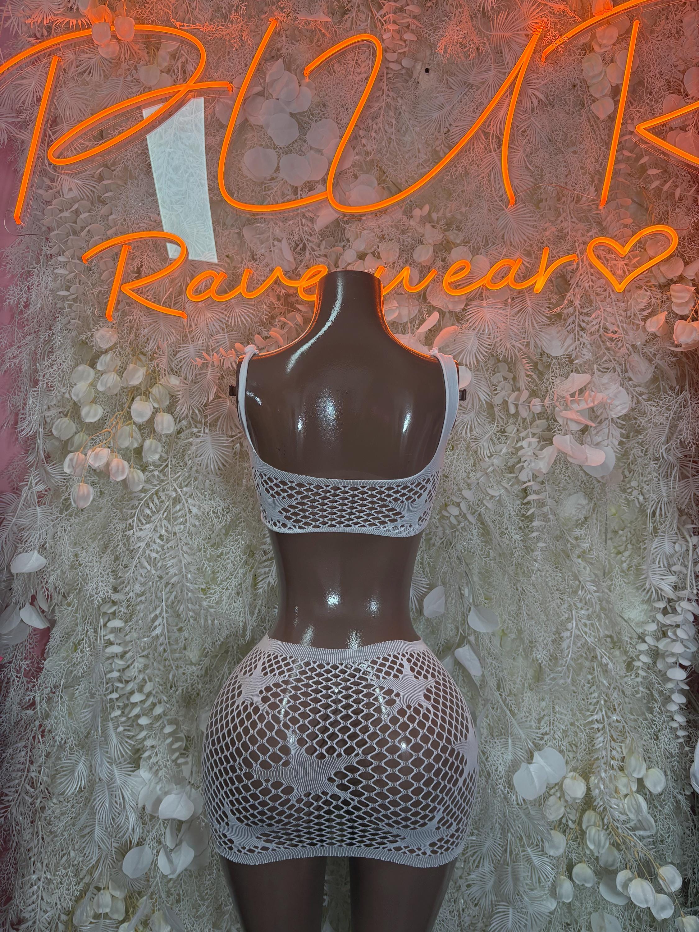 White fishnet mini skirt with matching backless cropped top, pinned accents