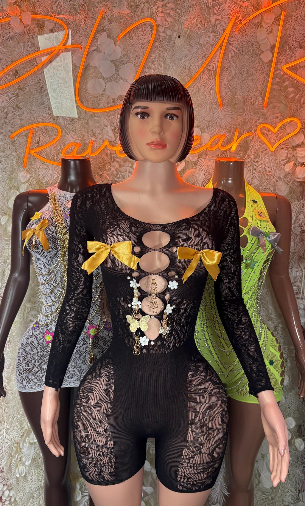 Black fishnet bodysuit with long sleeves and bow-and-chest embellishment