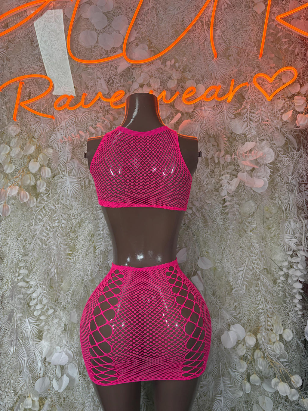 Pink fishnet crop top and mini skirt set on mannequin, back view