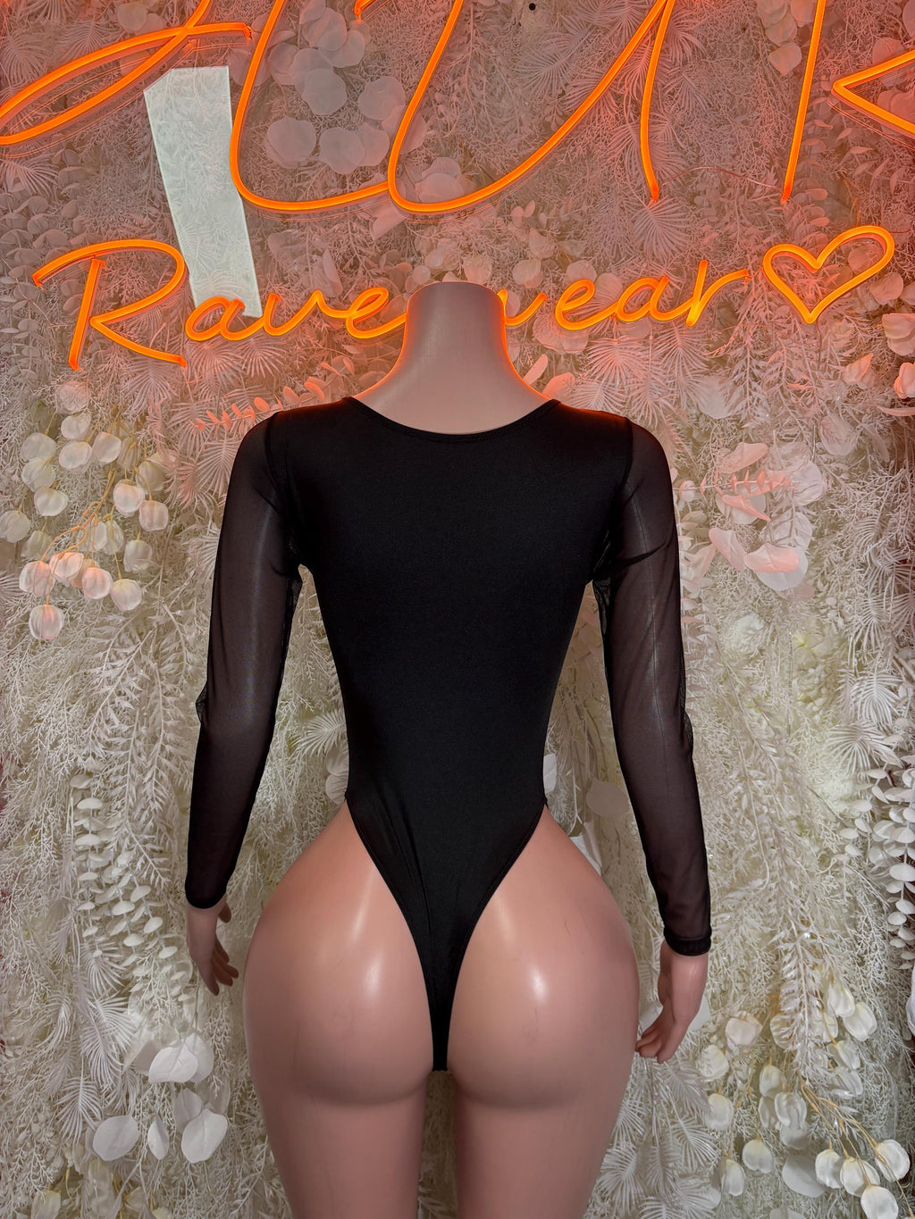 Black one-piece bodysuit with long sheer sleeves and high-cut leg openings