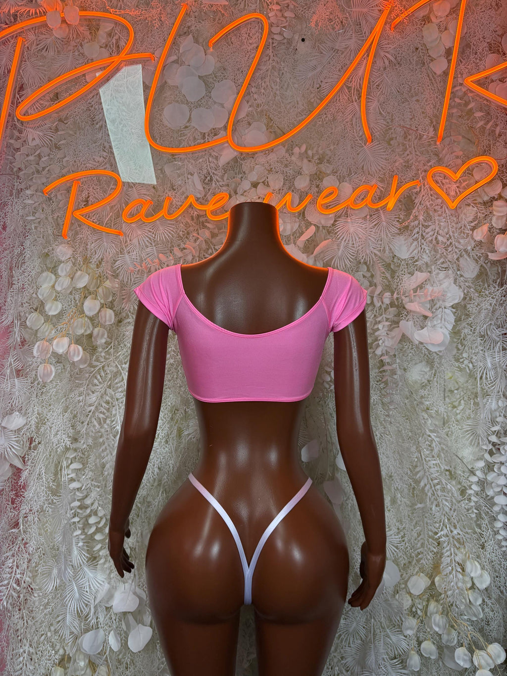 Pink scoop-back bikini top with matching thong bottom and white lace-up trim