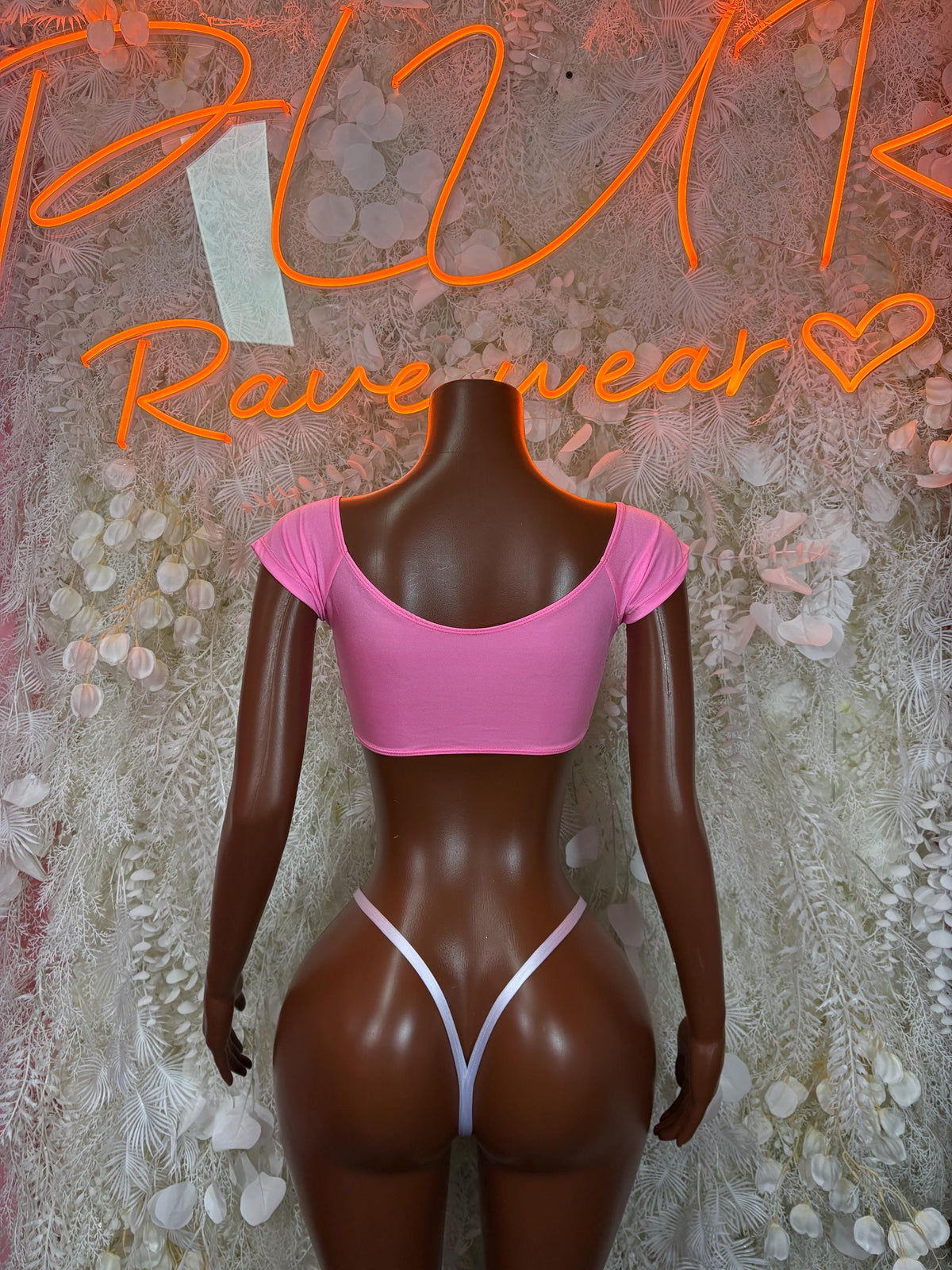 Pink scoop-back bikini top with matching thong bottom and white lace-up trim
