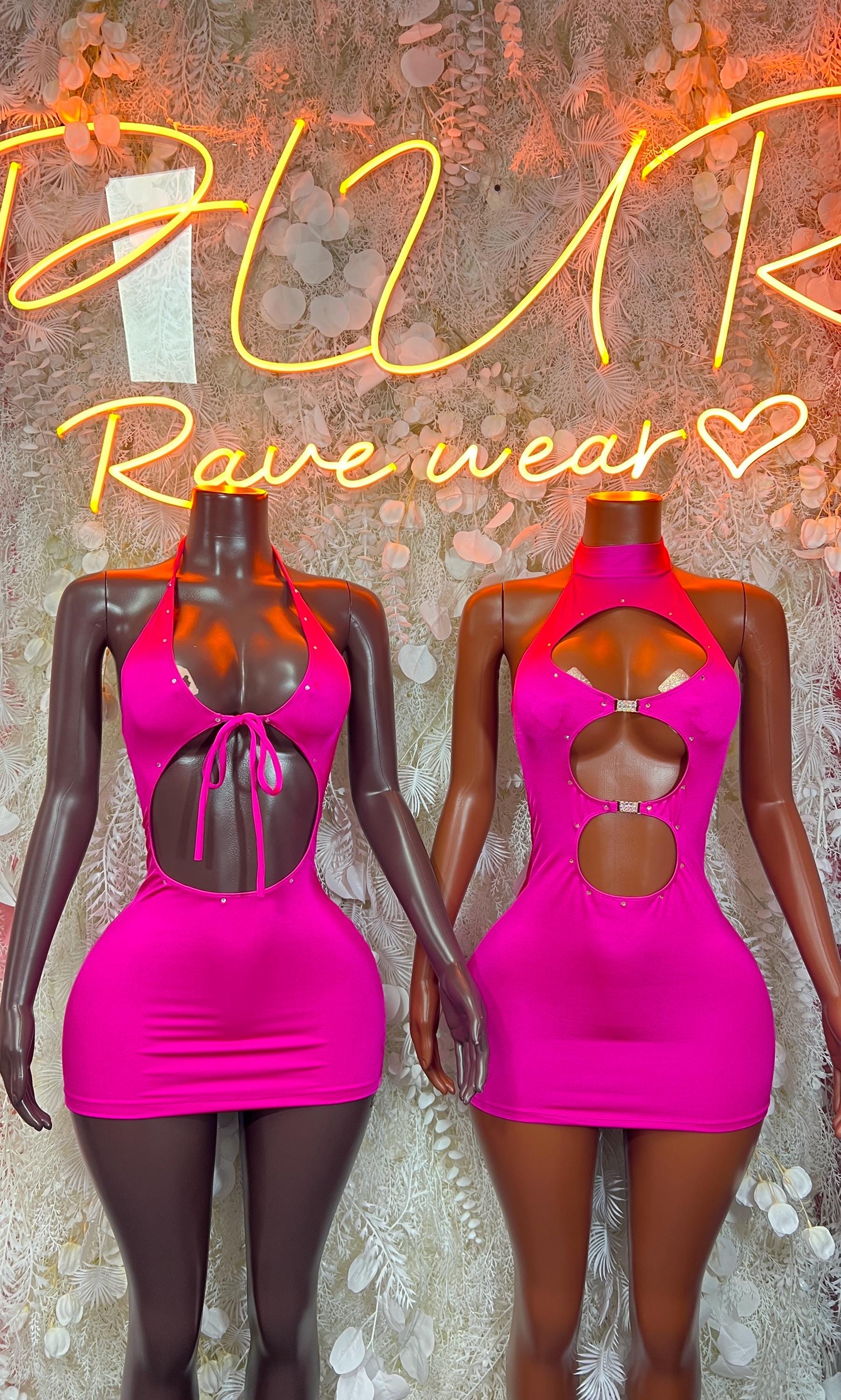 Pair of pink halter mini dresses on mannequins, one front and one open-back