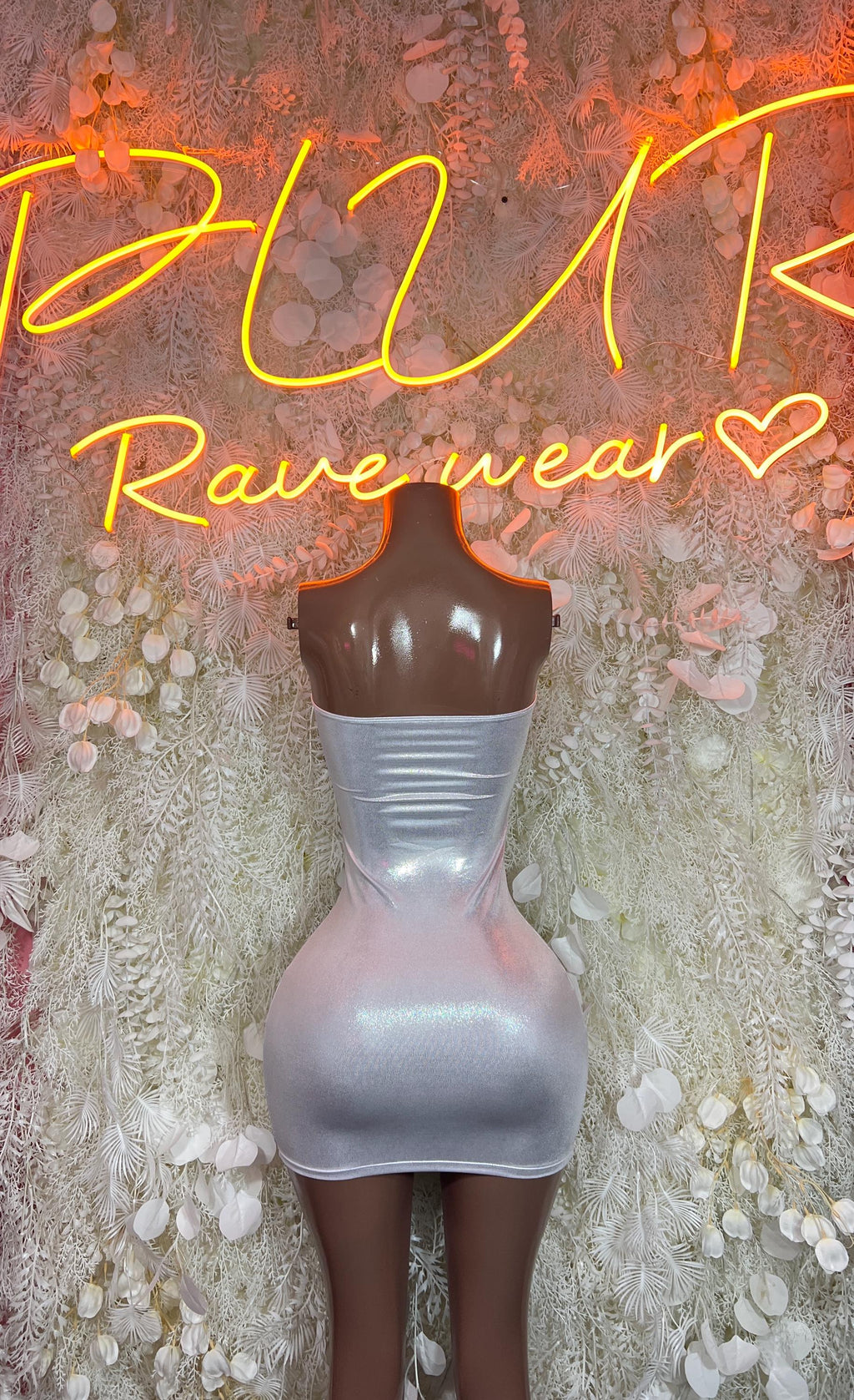 Silver holographic mini dress on mannequin, sleeveless with draped bodice