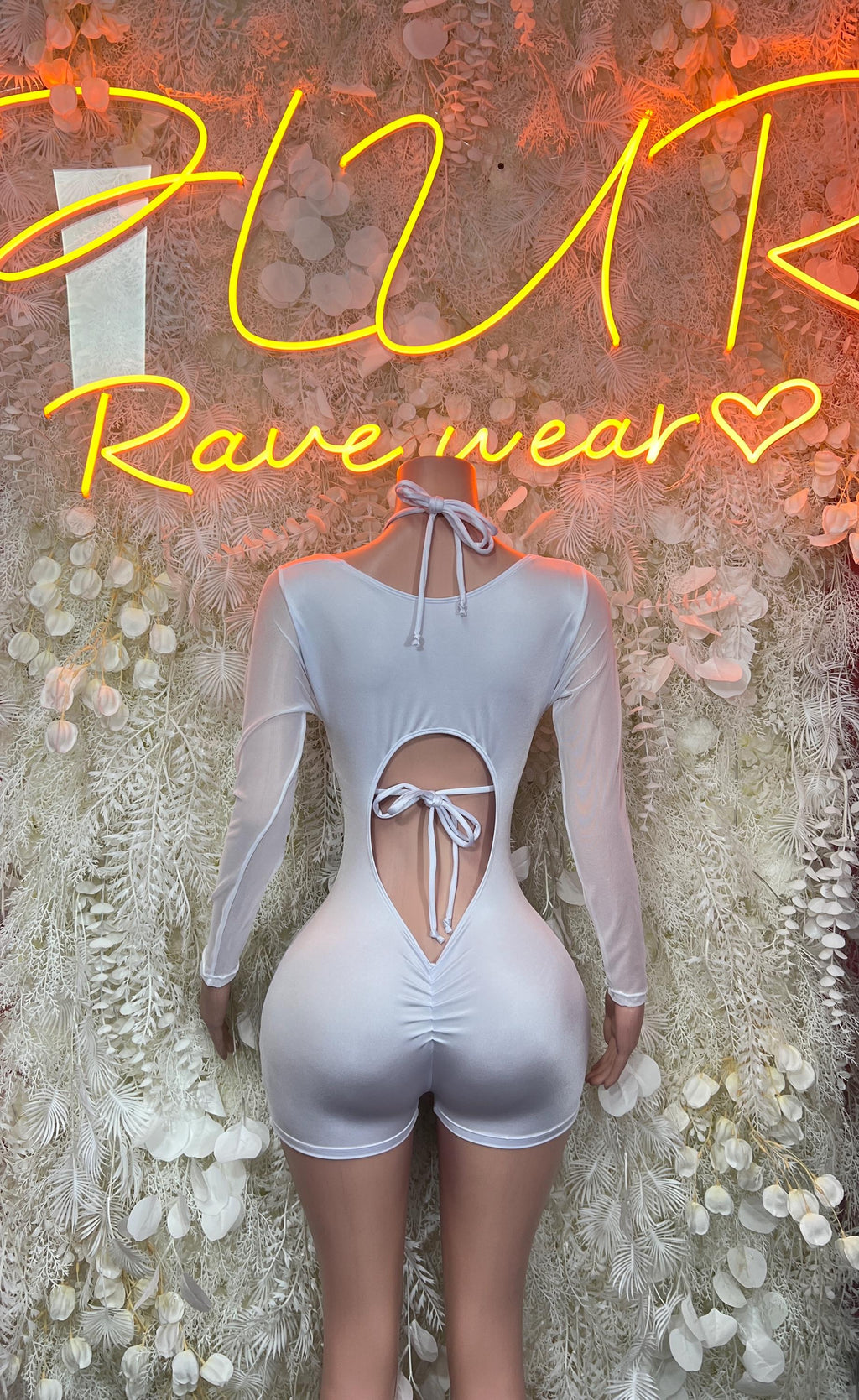 White long-sleeve bodysuit with deep V cutout, ribbon tie front, shorts bottom