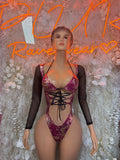 Metallic magenta one-piece bodysuit with black lace-up front and sheer long sleeves