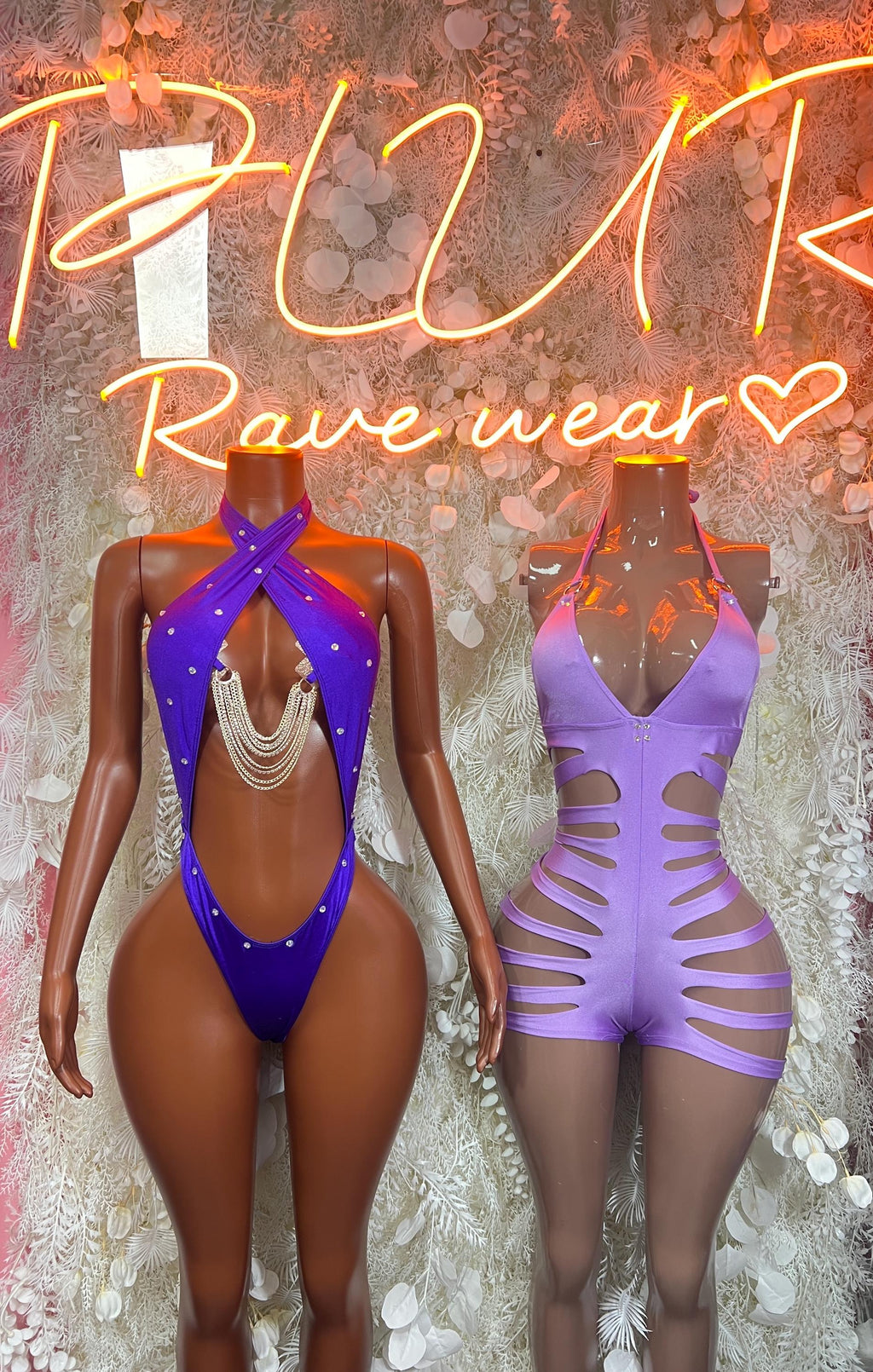 Purple halter one-piece bodysuit with lace-up cutouts, beside a blue one-piece