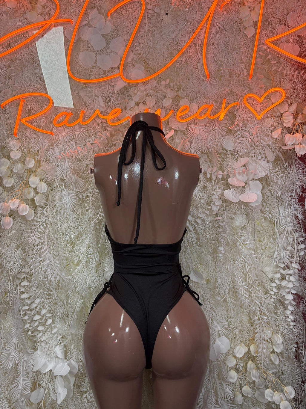 Black one-piece bodysuit with open back and sheer mesh panels