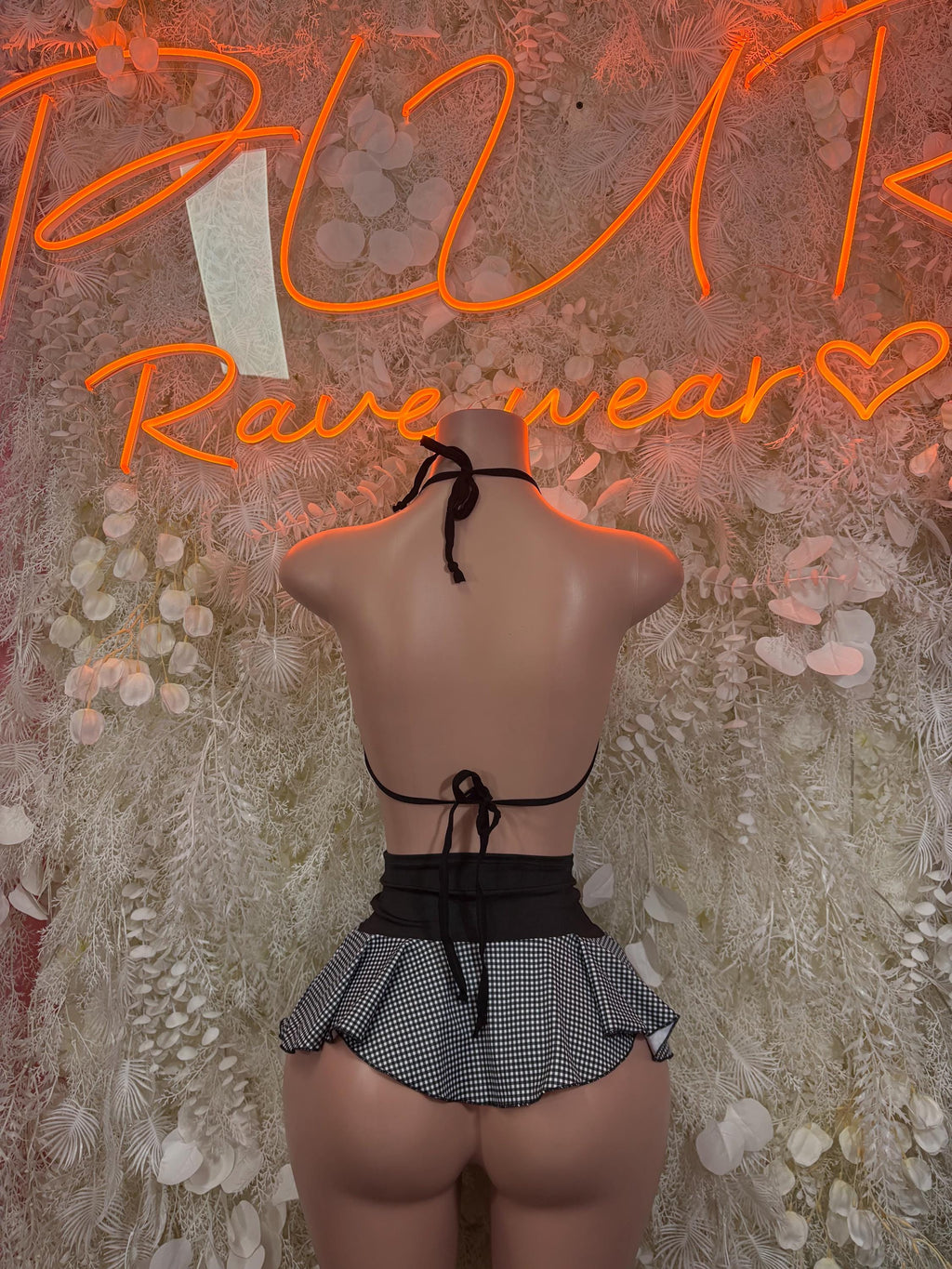Rave outfit two-piece skirt set, back view: black tie bikini top and pleated check mini skirt
