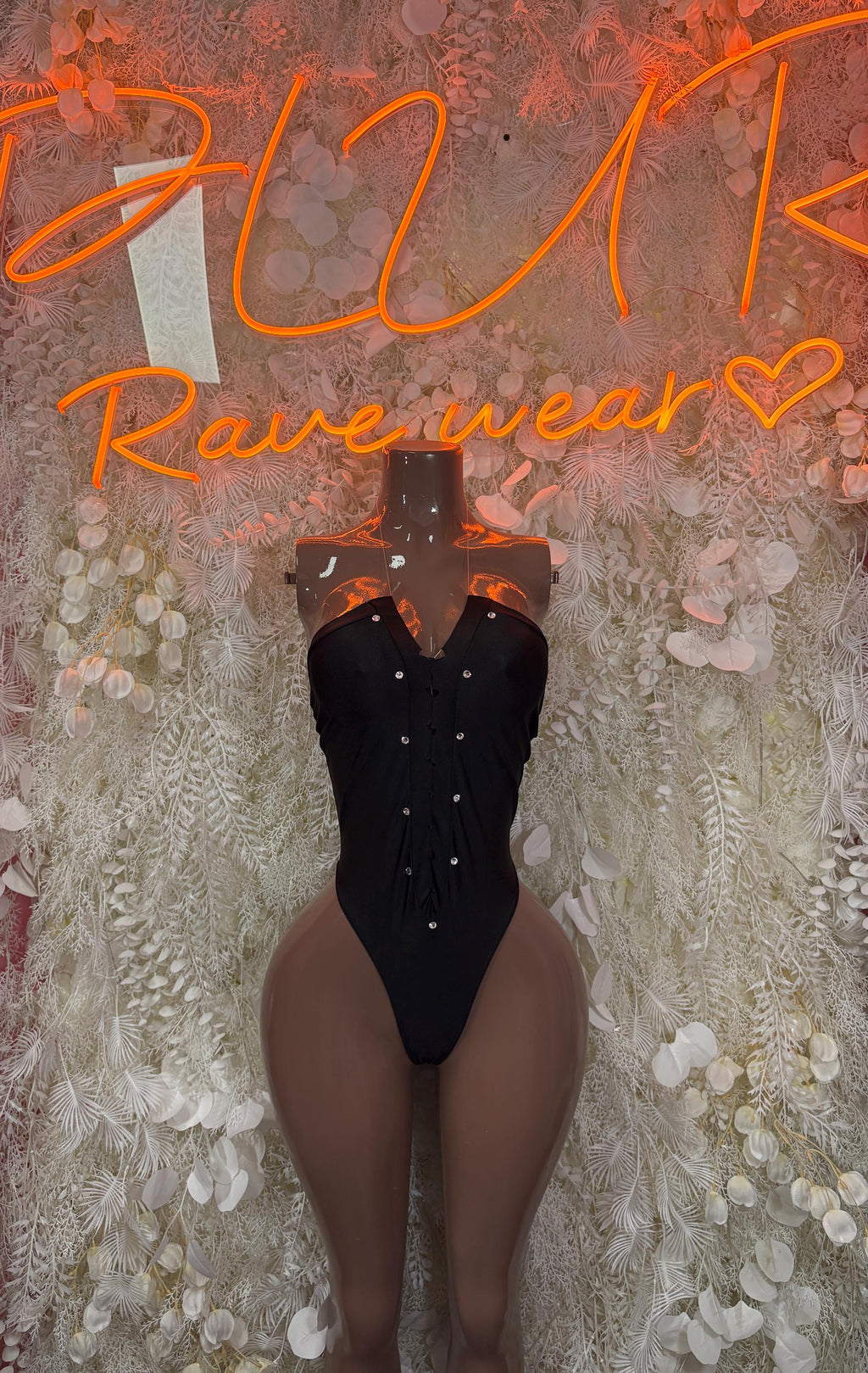 Black V-neck bodysuit with button details and high-leg thong cut