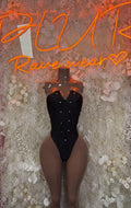Black V-neck bodysuit with button details and high-leg thong cut