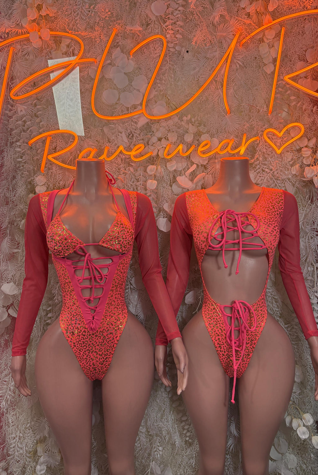 Two coral animal-print bodysuits with long sleeves and lace-up front details