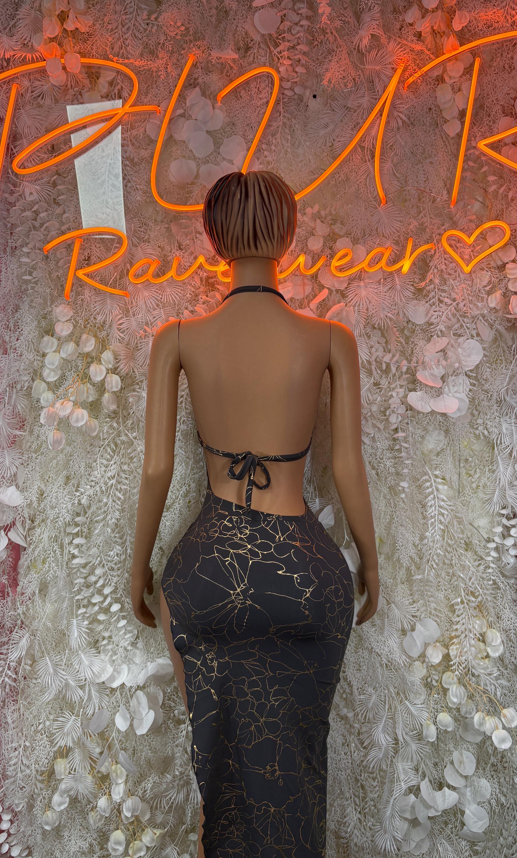 Black halter bodycon gown with gold-tone pattern, open back and tie bow detail