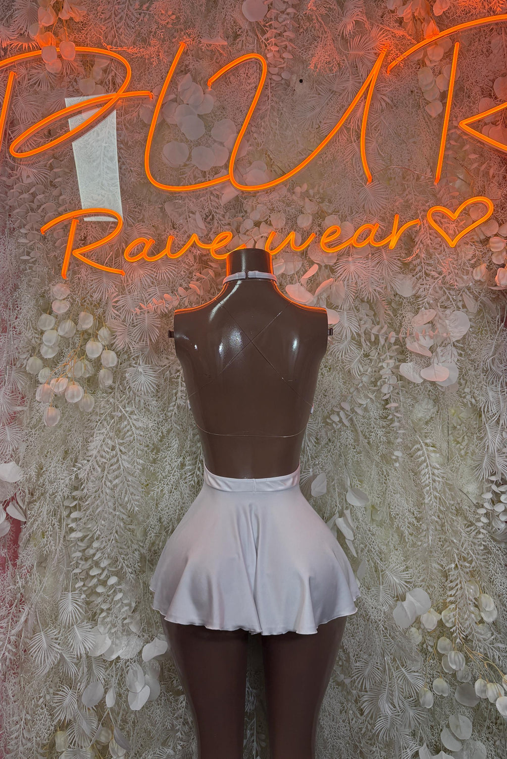 White mini skirt with flared hem on fitted bodice top, halter neckline