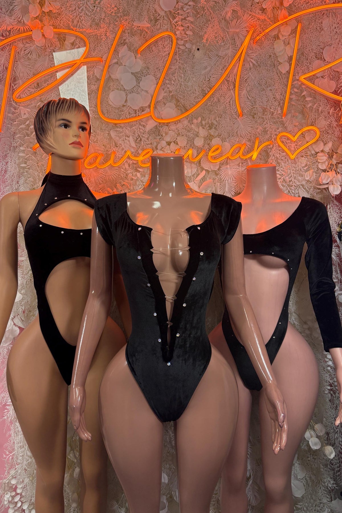 Black velvet bodysuit worn by model, deep V front and high-cut bottom with long sleeves