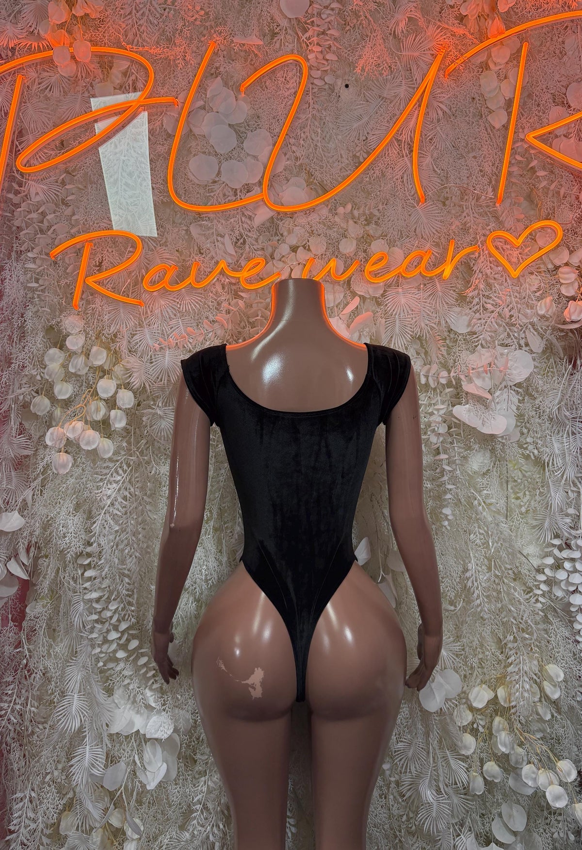 Black velvet bodysuit on mannequin, deep V neckline and high-cut bottom with long sleeves