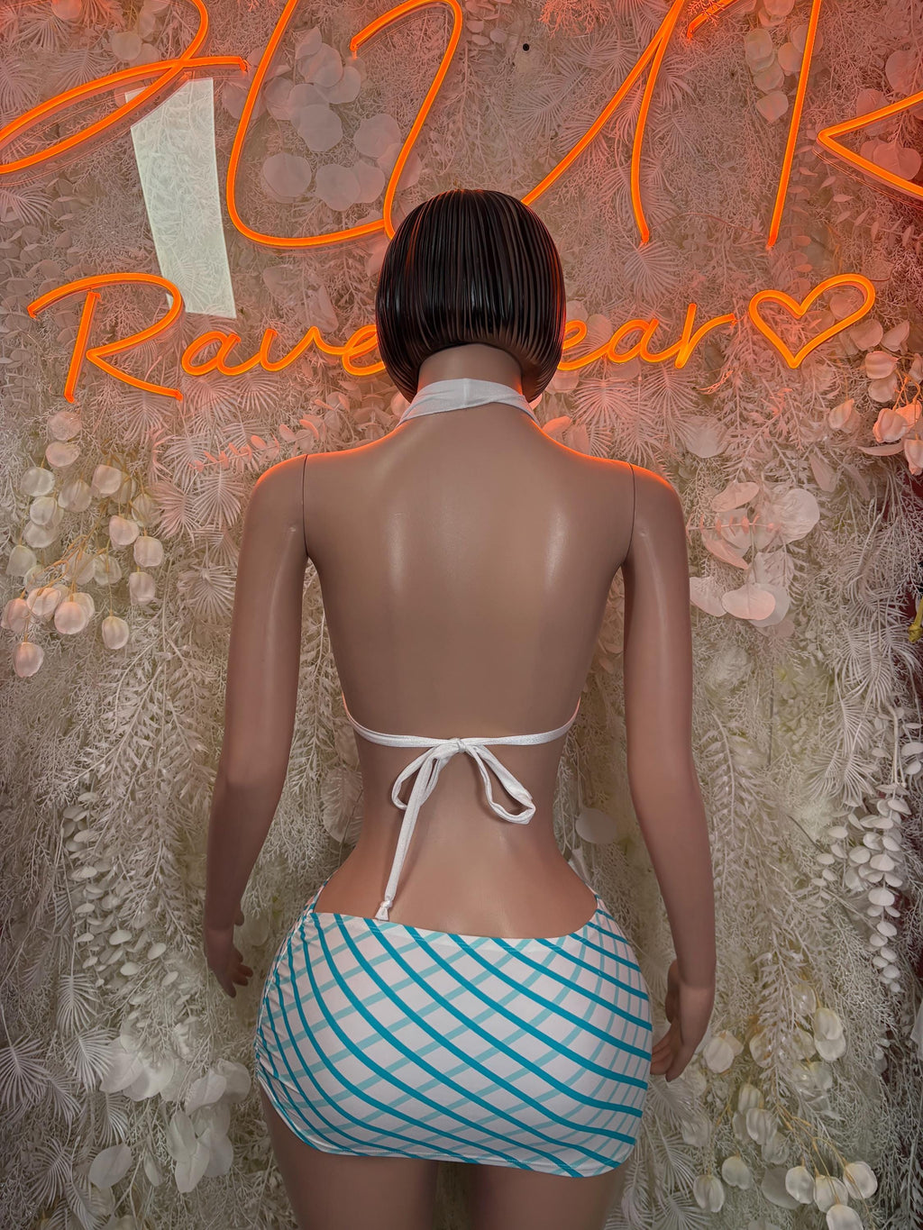 Back view: white tie-back halter bikini top with blue striped mini skirt