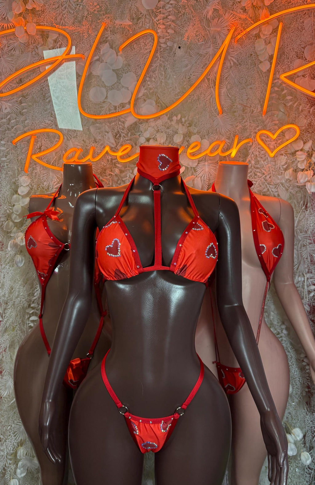 Red heart-print triangle bikini top and matching bottom with shoulder ties on mannequin