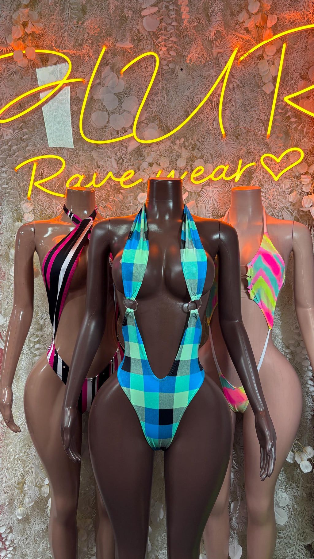 Multicolor patterned rave bodysuit on mannequin, halter tie and high-cut leg