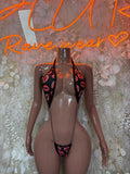 Black sheer lingerie bodysuit with heart cutouts and red kiss print