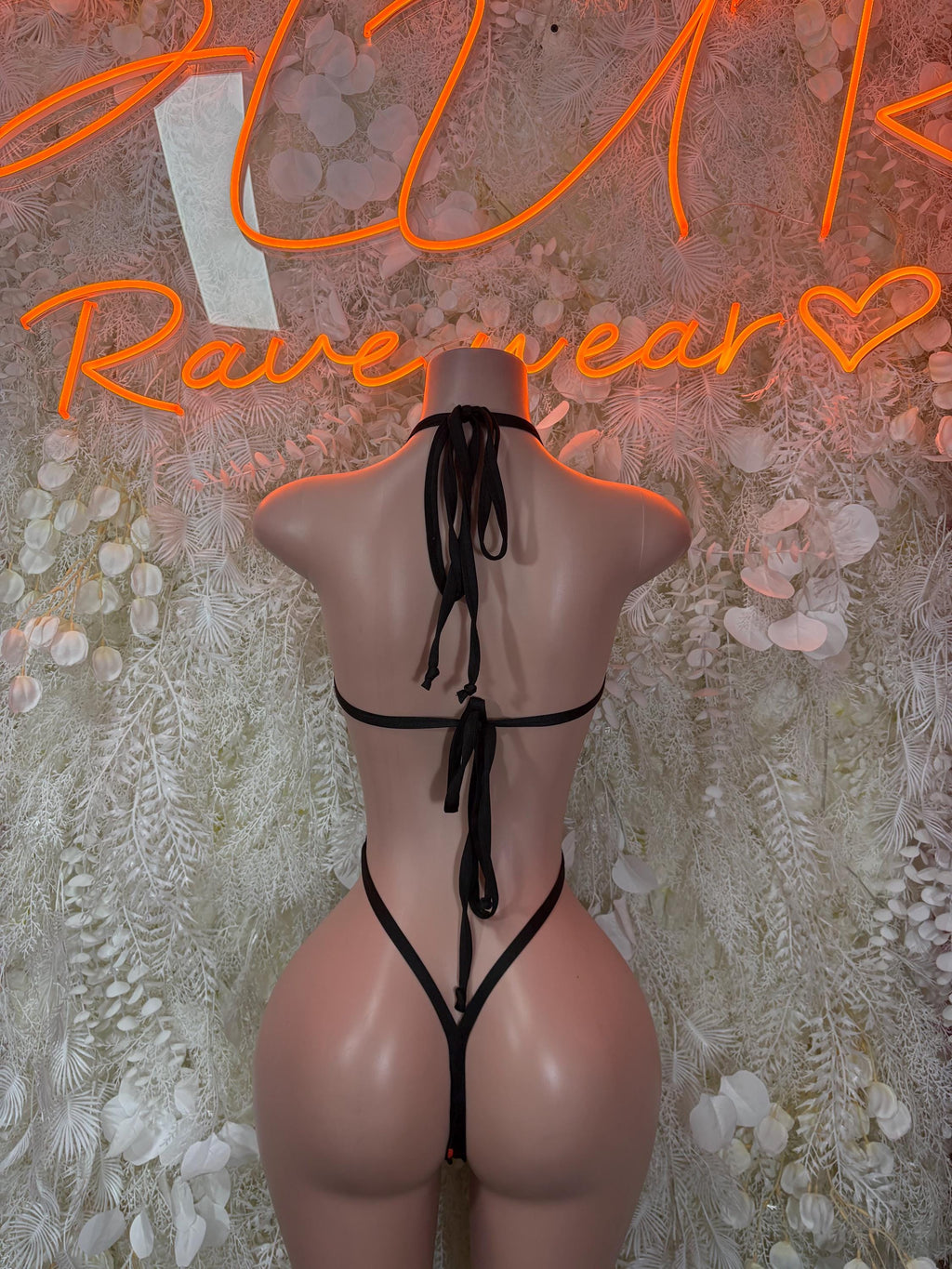Back of heart-print lingerie bodysuit with long tie, black base and heart accents