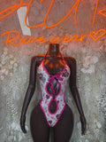 Pink and white patterned lingerie bodysuit with tie straps and cutout front