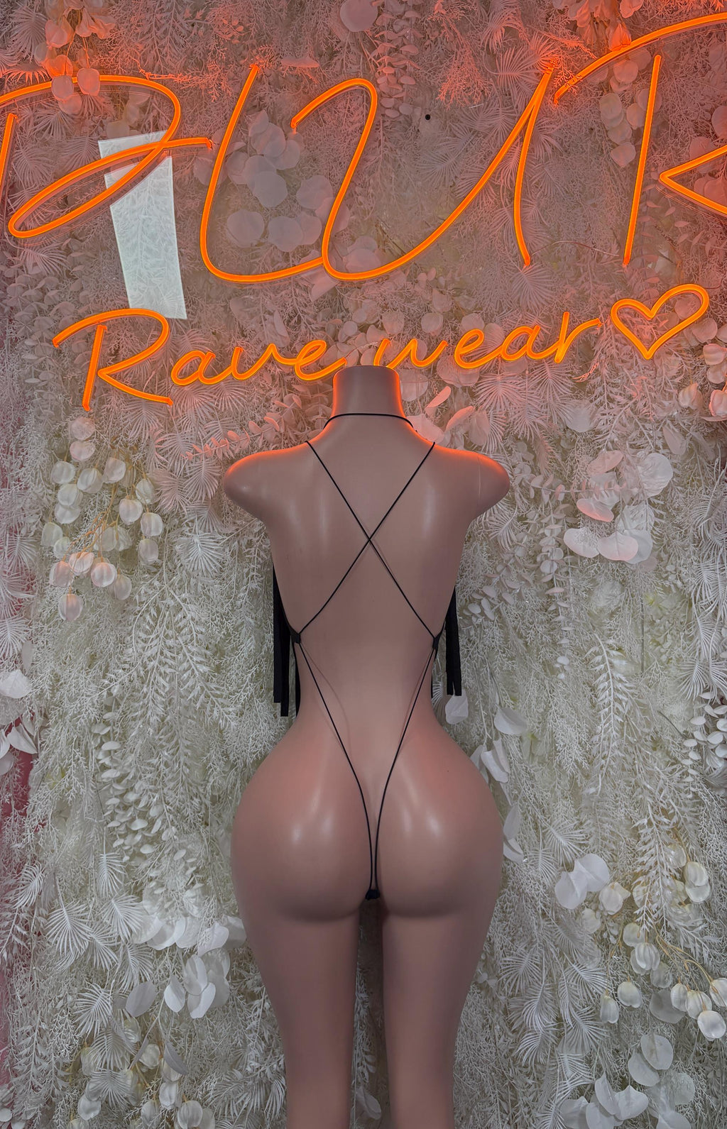 Black bodysuit back view with cross straps and dangling fringe tassels
