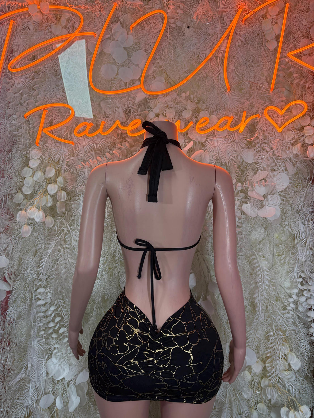 Black backless mini dress with gold line pattern, halter tie and bow at back