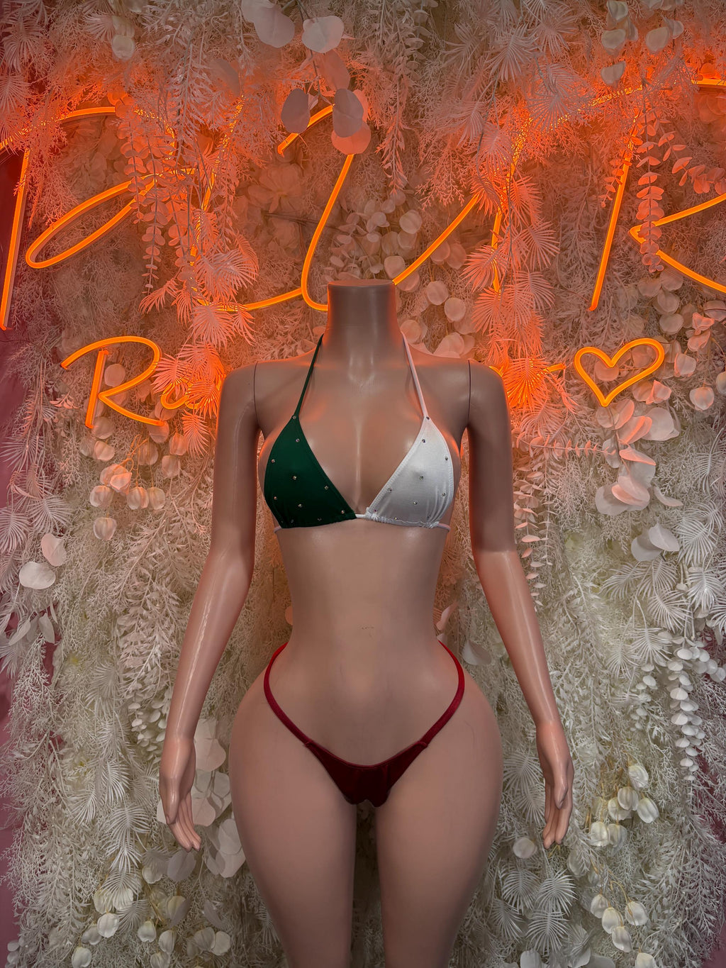 Two-piece bikini: green triangle top, red high-cut bottoms with white tie straps
