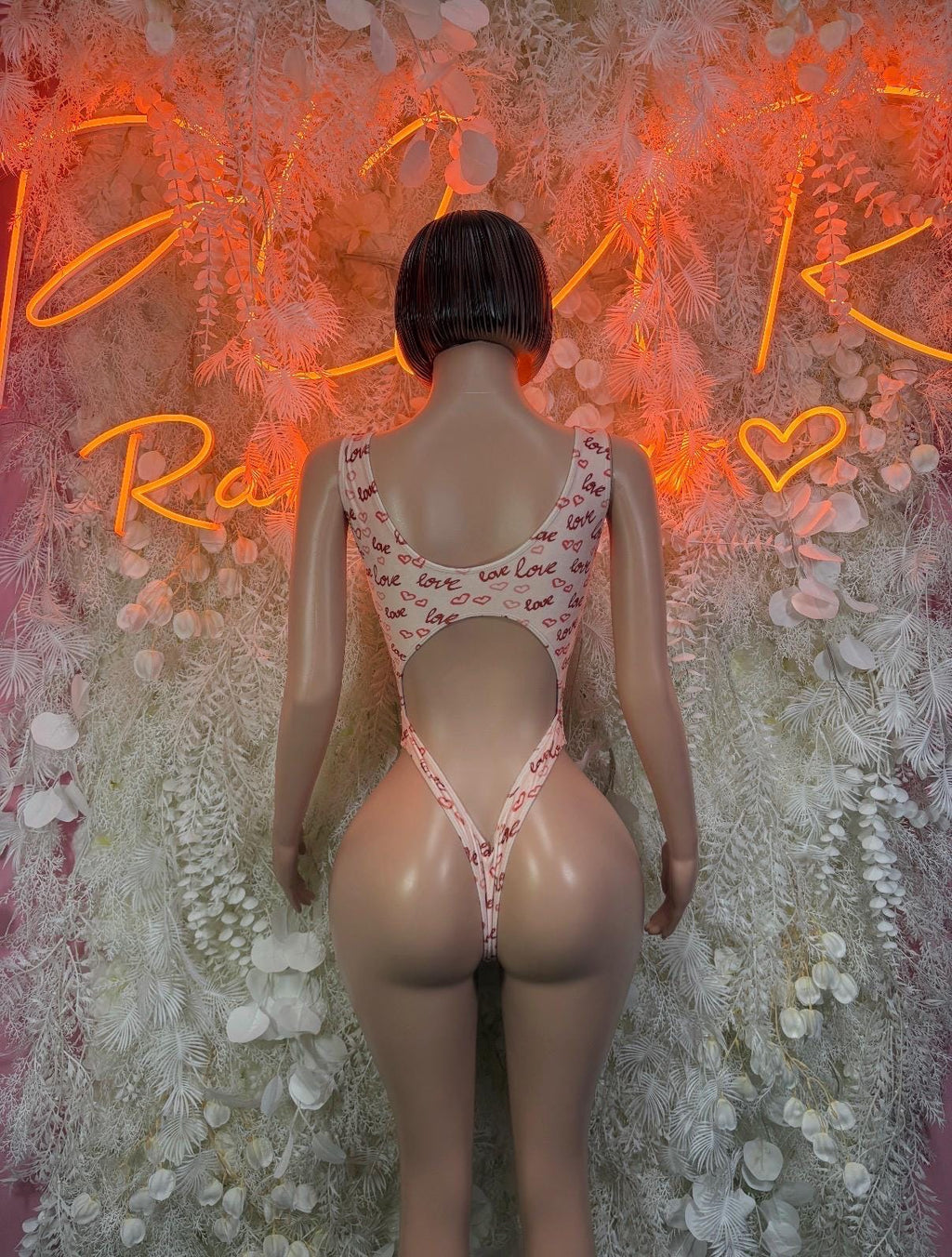 Back view of white heart-print thong bodysuit with open back straps
