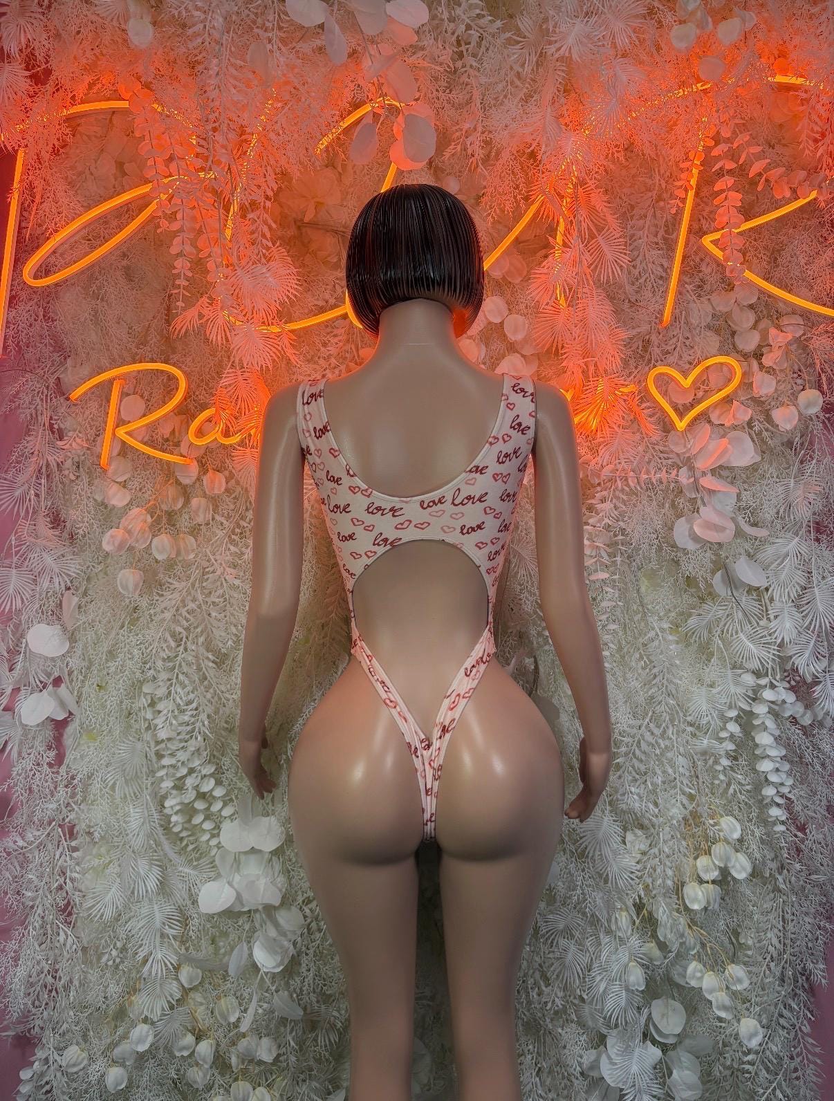 Back view of white heart-print thong bodysuit with open back straps
