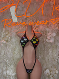 Heart-print lingerie bodysuit with black straps and open sides, front view
