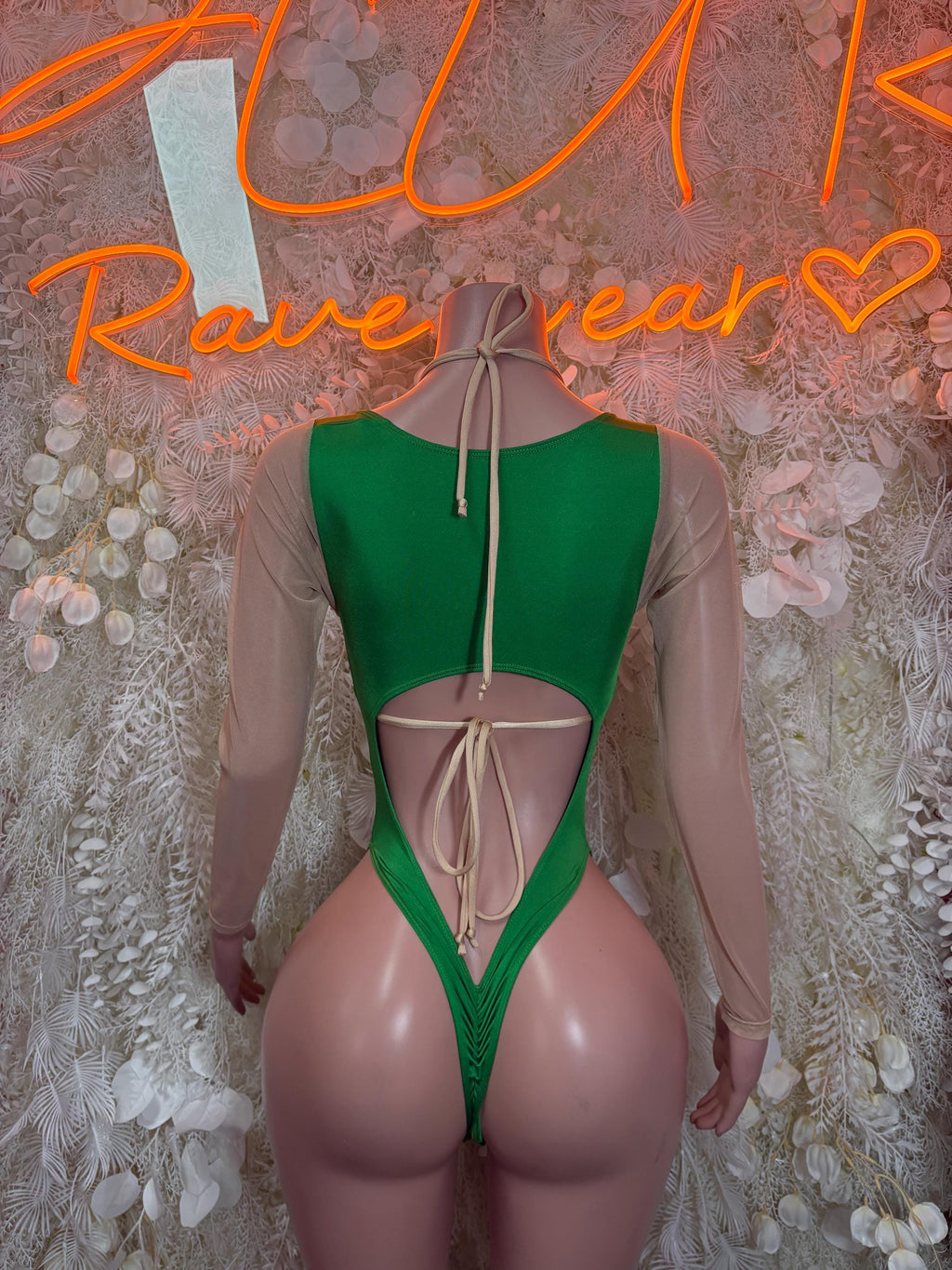 Green thong-style bodysuit with open-back ties and sheer long sleeves