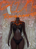 Black one-piece bodysuit with gold web pattern and V neckline