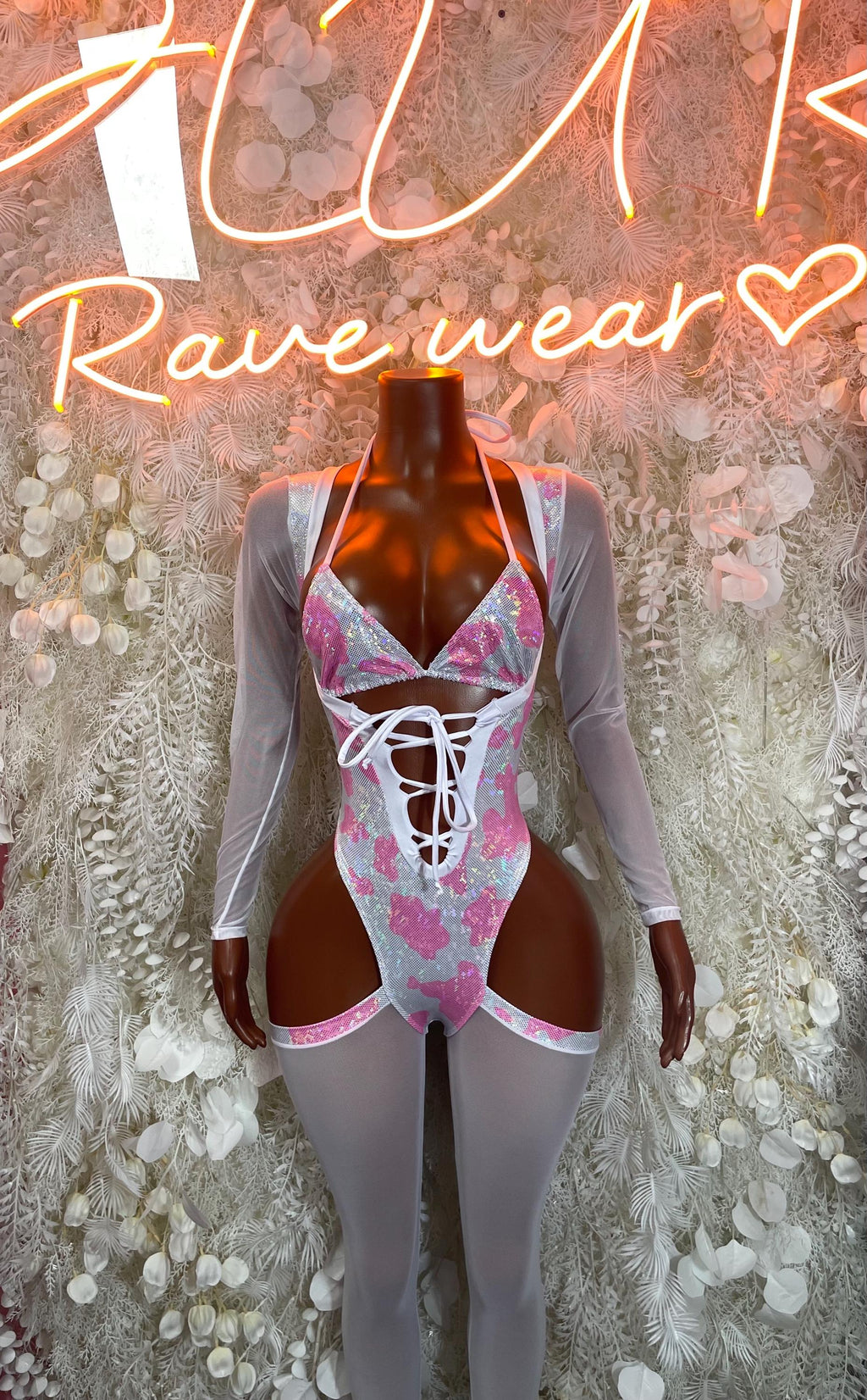 Pink cow print bodysuit with long sleeves and crisscross lace-up front