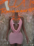 Baby pink mini dress with halter cowl neckline and ruched fitted skirt on mannequin