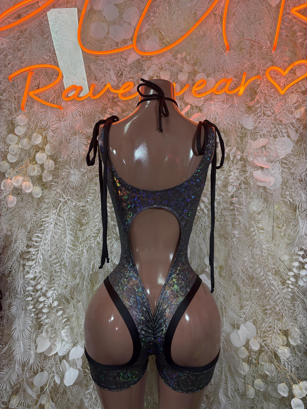 Black metallic lace-up bodysuit with triangle bust cutouts and high-leg shorts