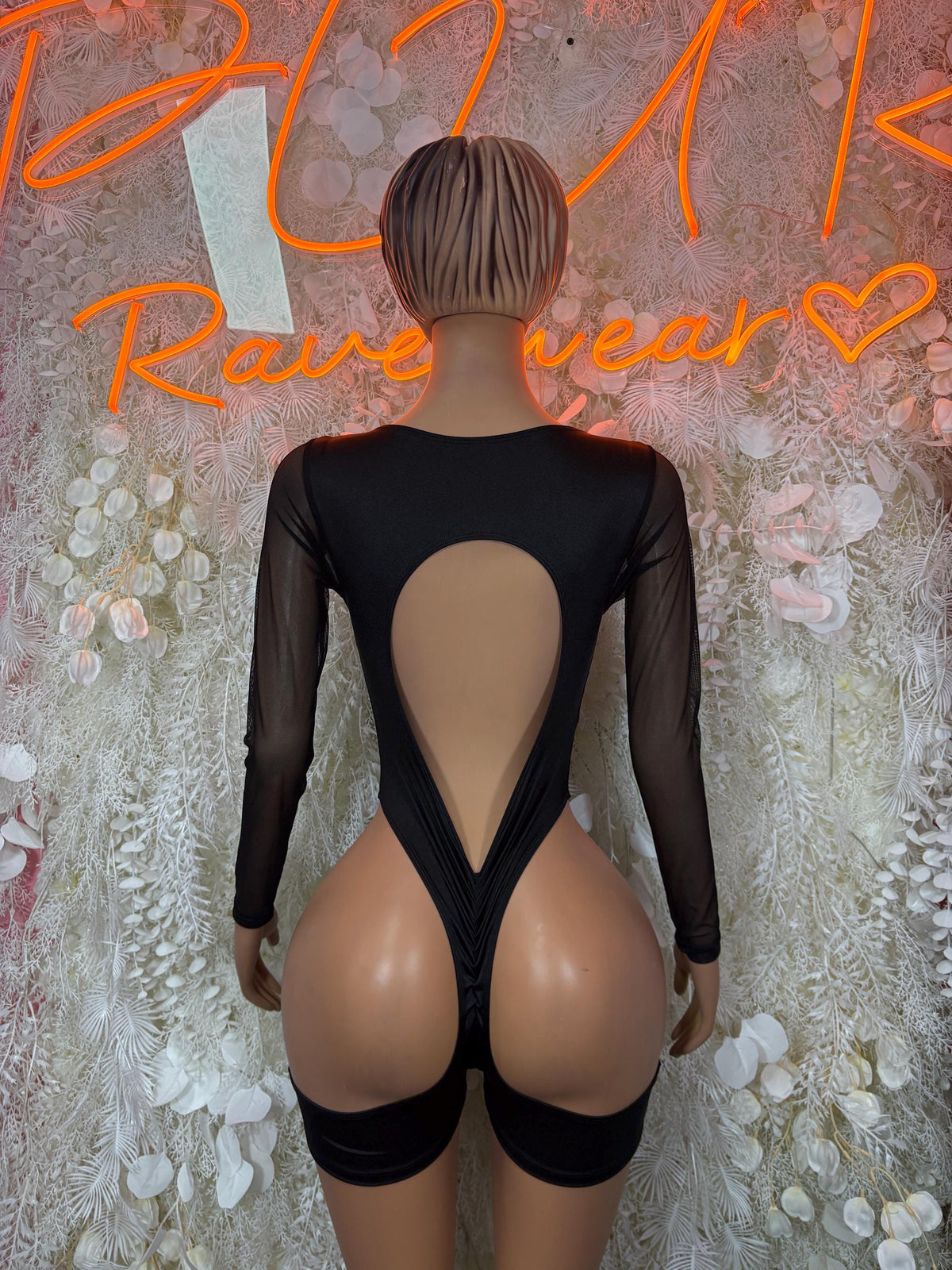 Black one-piece outfit with sheer long sleeves and open-back cutout
