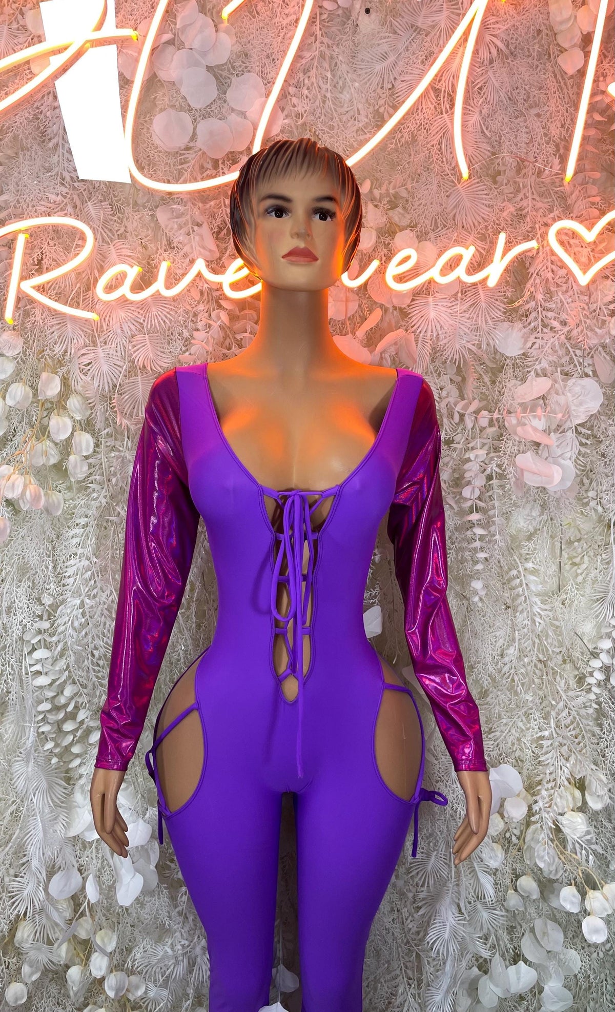 Purple one-piece bodysuit with long sleeves, lace-up neckline, and side cutouts.