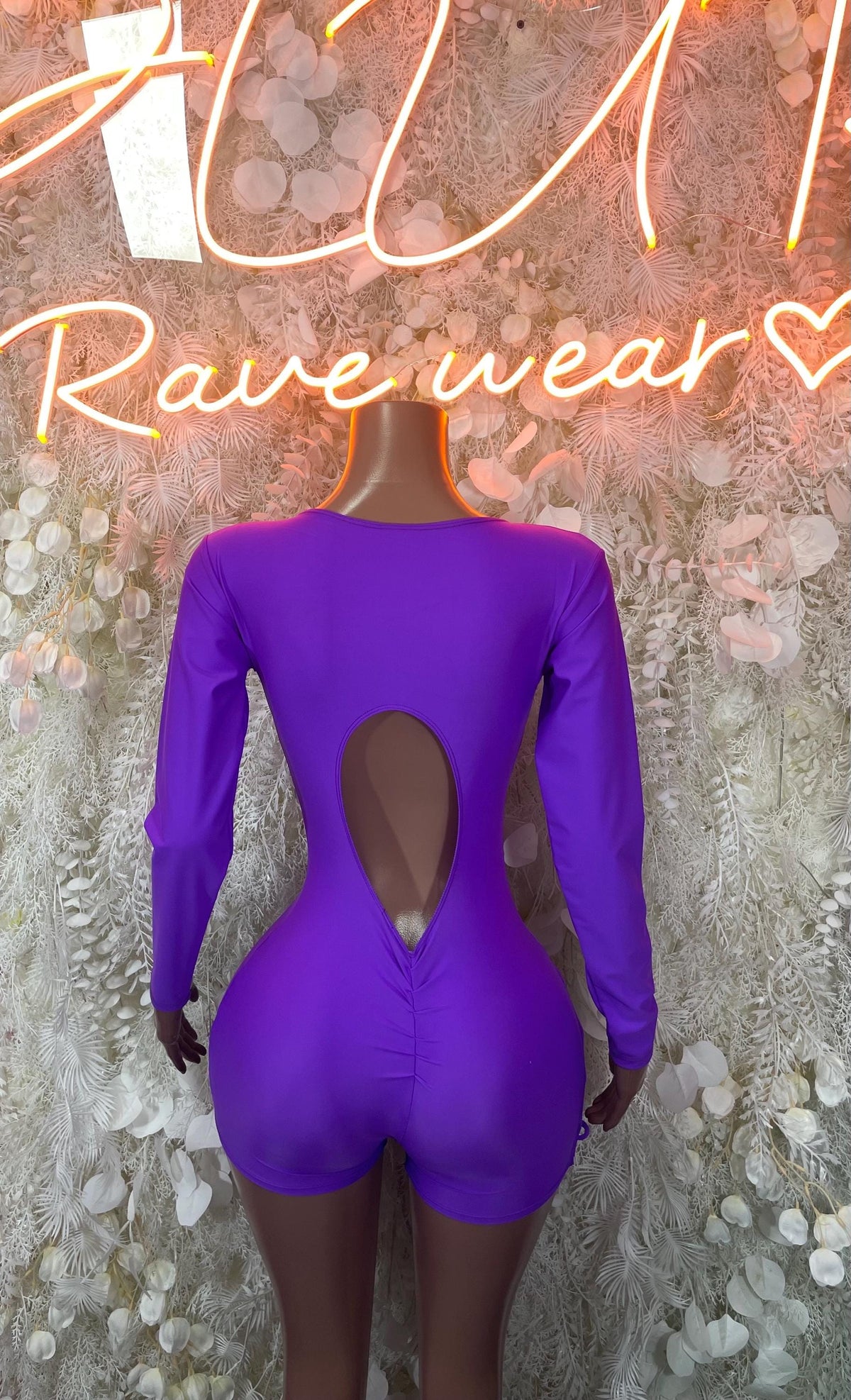 Purple long-sleeve one-piece bodysuit with open back V-shape and fitted legs
