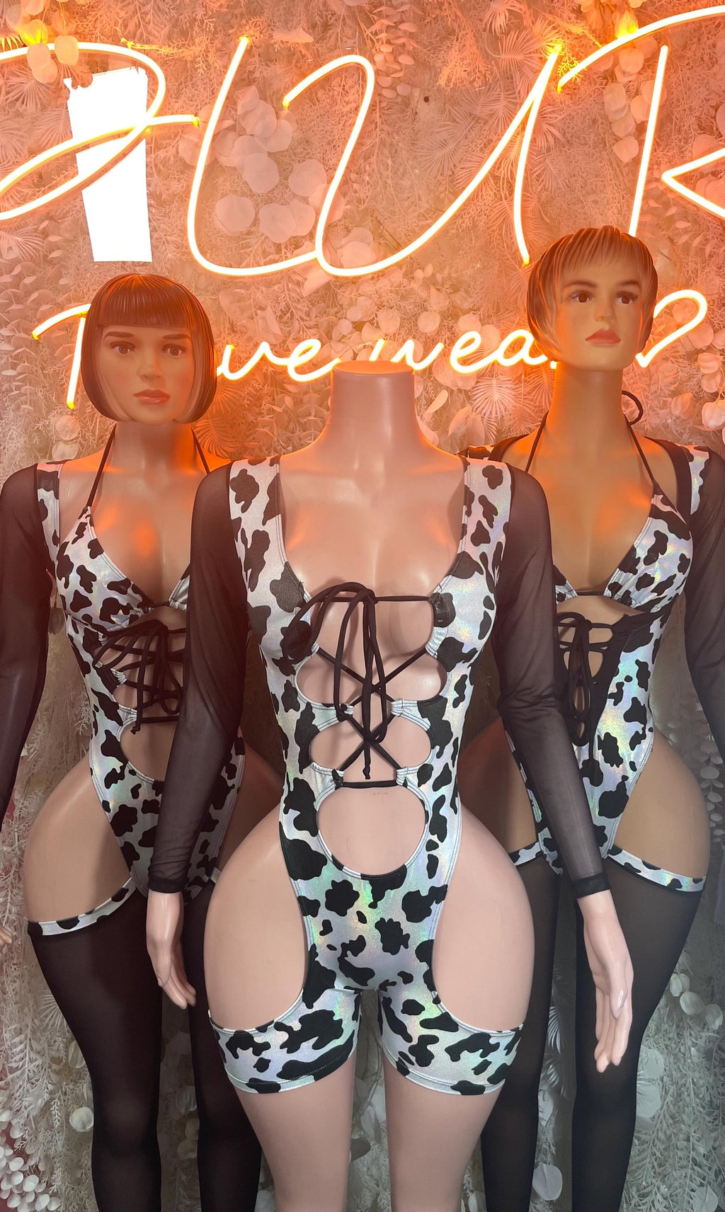 Cow print bodysuit with black mesh long sleeves and lace-up front straps