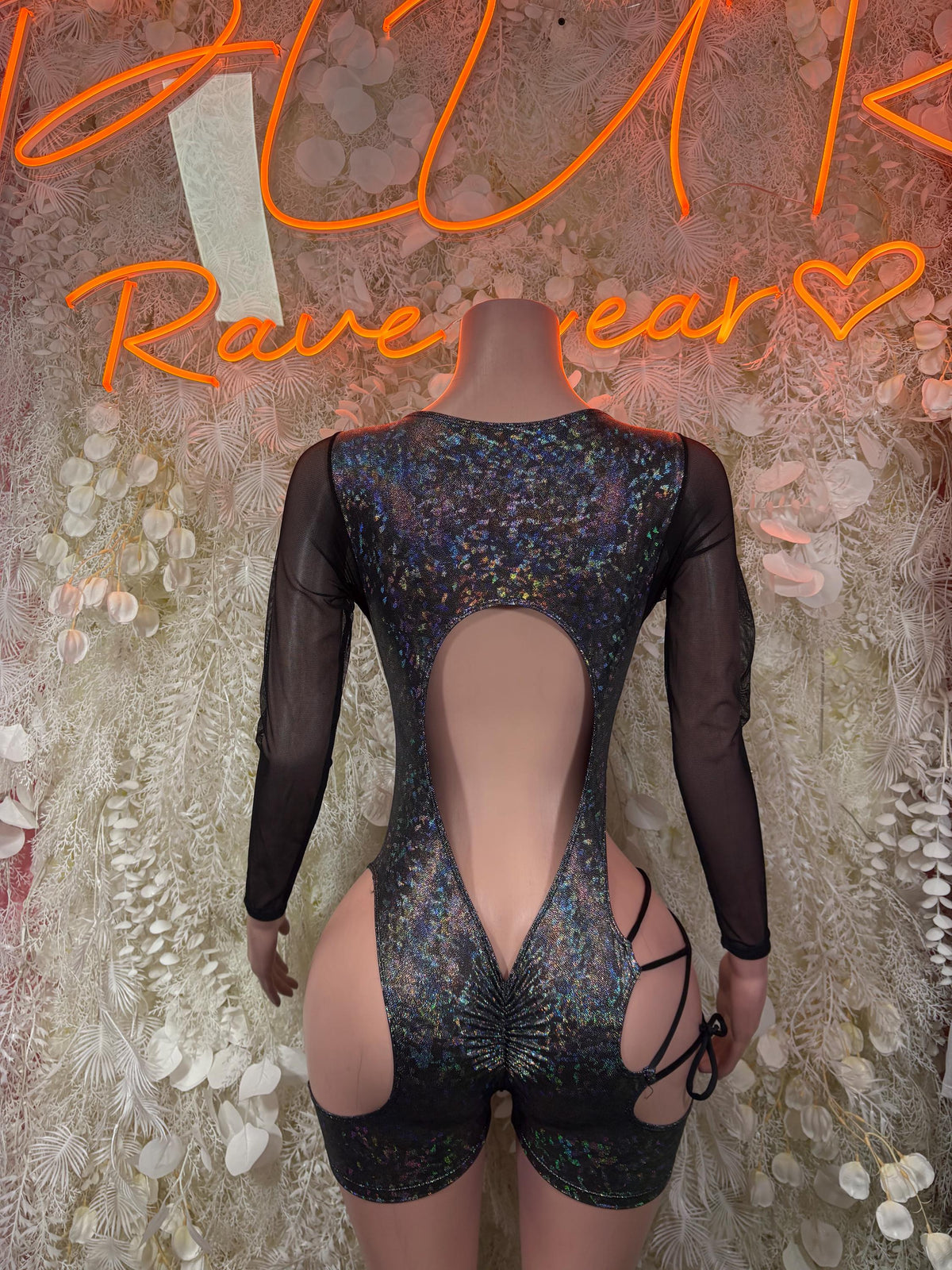 Black sheer long-sleeve bodysuit, back view, with holographic metallic lace-up cutout