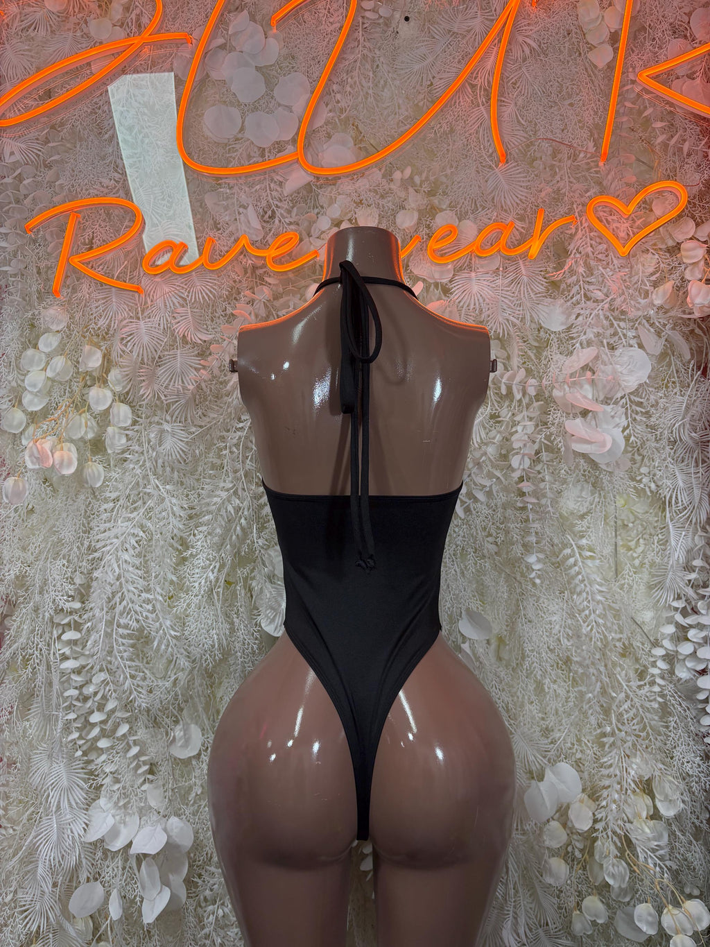 Black open-back bodysuit with back tie straps and high-cut leg