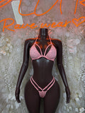 Pink rhinestone triangle bikini set with harness-style straps on dark lingerie mannequin