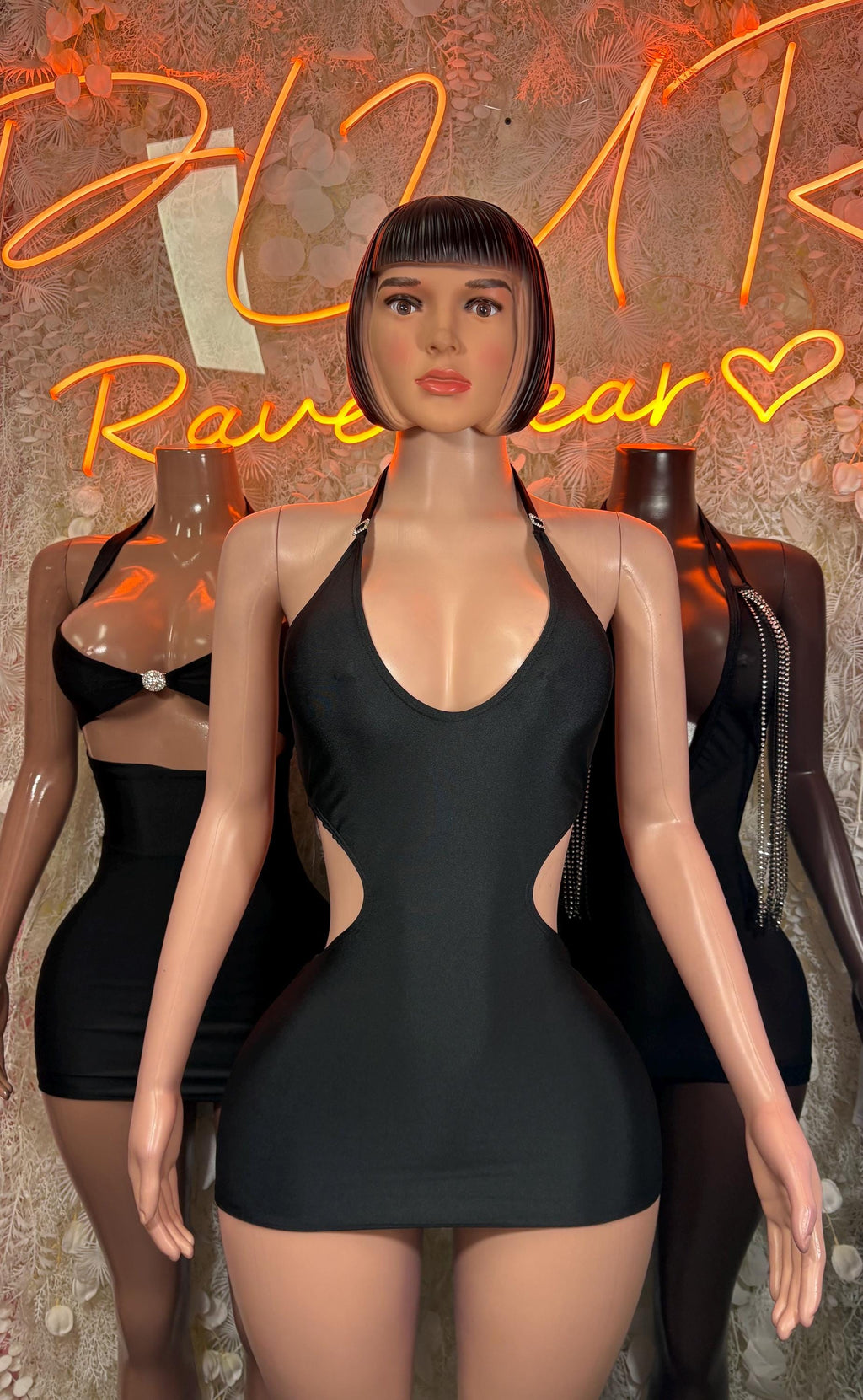Black halter mini dress on model, sleeveless with V neckline and short hem