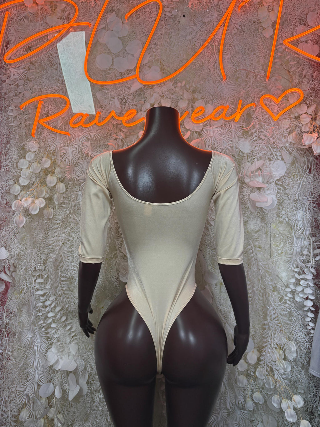 Tan one-piece bodysuit with scooped back and long sleeves